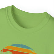 Close-up of the upper part of a light green Spooky Nights Halloween Ultra Cotton Tee (Unisex) from Printify featuring a retro-style graphic design in red, yellow, and blue colors. The shirt collar and part of the chest area are visible. This inspirational wear aims to dare to inspire those who see it with its vibrant design.