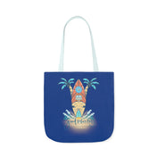 A blue tote bag featuring an illustration of a surfboard on a sandy beach, flanked by two palm trees. Waves flow at the base of the surfboard with the text "Good Vibes Only" beneath the scene, inviting you to dare to inspire. The handles of the bag are light blue. Introducing the Surf's Up Good Vibes Only Beach Tote by Printify.