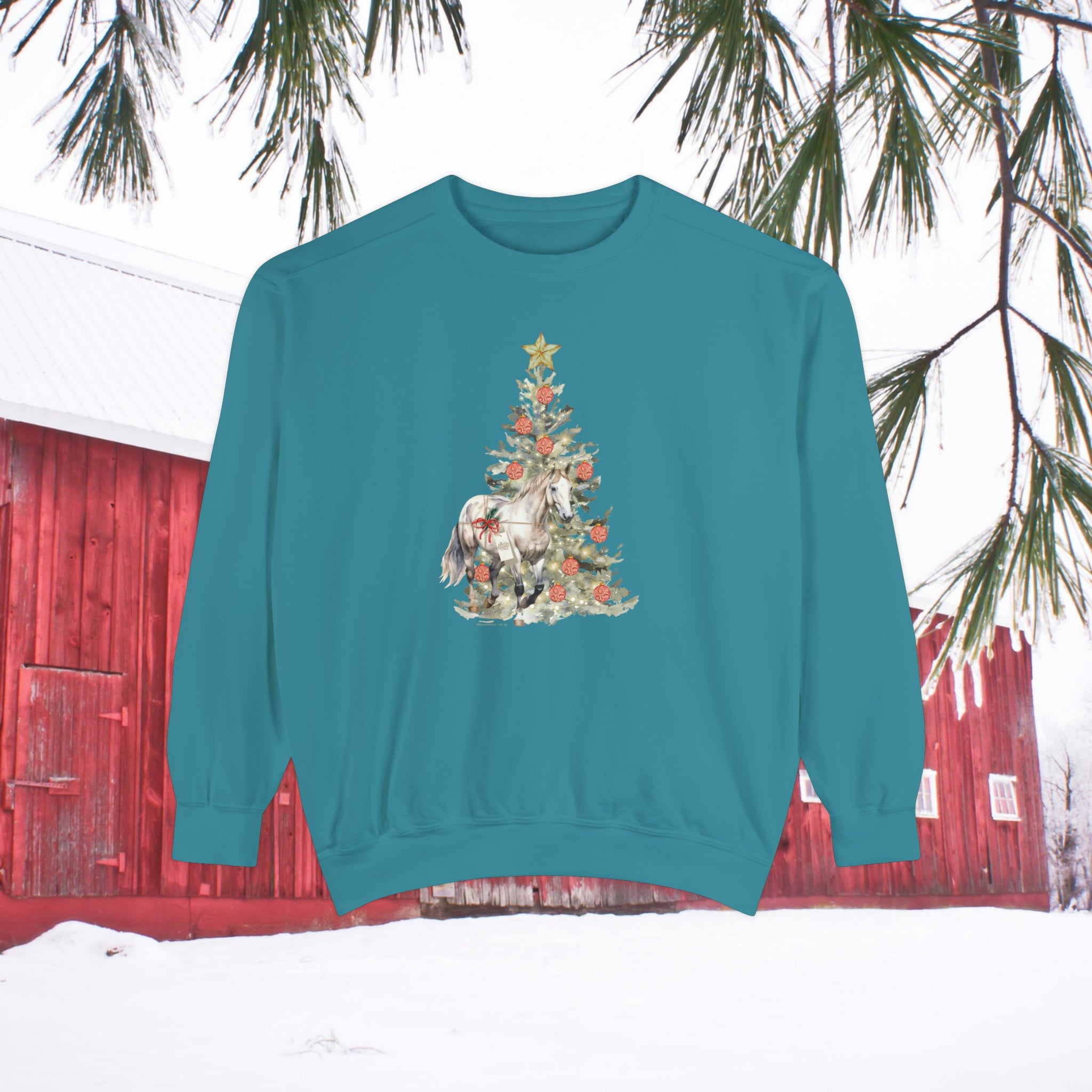 Introducing the Urban SoulShine & co's "The Gift of A Horse Christmas Garment-Dyed Sweatshirt," a teal unisex piece featuring a festive print of a Christmas tree, horse, and decorative elements. With its relaxed fit, this sweatshirt is set against the vibrant imagery of a red barn, snowy ground, and pine branches, offering both comfort and seasonal charm.