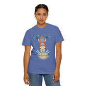 A person wearing a Printify Surf's Up! Good Vibes Only Tee (Unisex) with a colorful palm tree and surfboard graphic, featuring the text "good vibes only." They have short braided hair, small hoop earrings, and jeans with a bracelet on their left wrist. This inspirational wear encourages you to express yourself boldly.