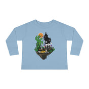 A young child with a slight smile stands against a plain background, wearing a gray long-sleeve shirt and blue jeans. The Spooky Island Halloween Toddler Long Sleeve Tee by Printify features a green, pumpkin-headed figure, a haunted house, and the phrase "Trick or Treat," showcasing an artistic expression perfect for the season.