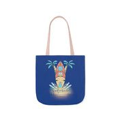 A blue tote bag with beige handles features an artistic expression of a surfboard between two palm trees. Waves are depicted at the bottom, with the text "Good Vibes Only" written below the design. The Surf's Up Good Vibes Only Beach Tote by Printify is perfect for your beach day essentials.