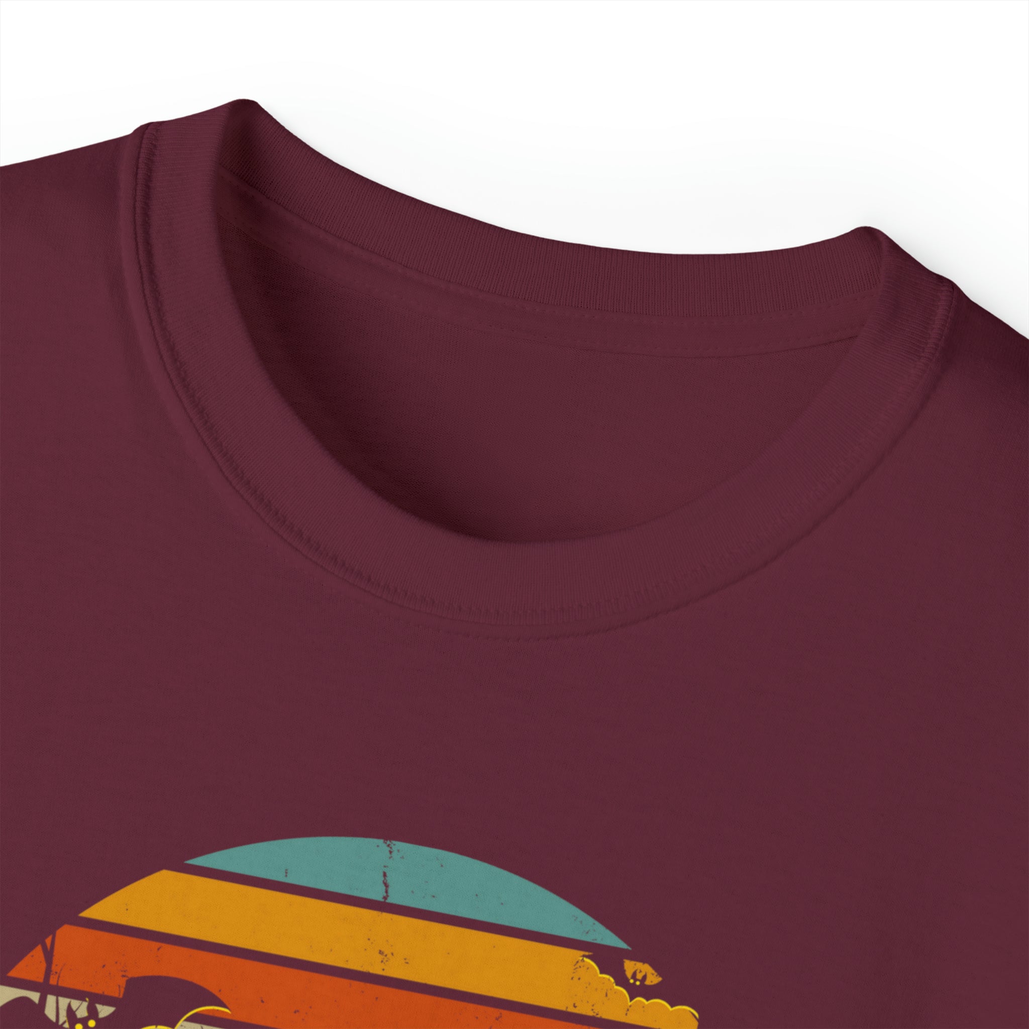 Close-up view of the collar of a maroon Spooky Nights Halloween Ultra Cotton Tee (Unisex) by Printify featuring a colorful graphic design with yellow, orange, red, and light blue stripes. Partial silhouettes of birds and trees are visible at the bottom, serving as an artistic expression to inspire creativity.