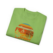 Folded green Spooky Nights Halloween Ultra Cotton Tee (Unisex) by Printify featuring a circular design with Halloween-themed elements, including a witch on a broomstick, a haunted house, and the word "Spooky" at the bottom. The design showcases vibrant colors such as red, orange, and yellow, inviting you to express yourself through artistic expression.