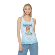 A person with long hair is wearing the Surf's Up Good Vibes Only Tie Dye Racerback Tank Top, made from lightweight fabric and featuring a graphic of a surfboard and palm trees with the message "Good Vibes Only" on the front. They are also dressed in light blue jeans from Urban SoulShine & co and are smiling at the camera.