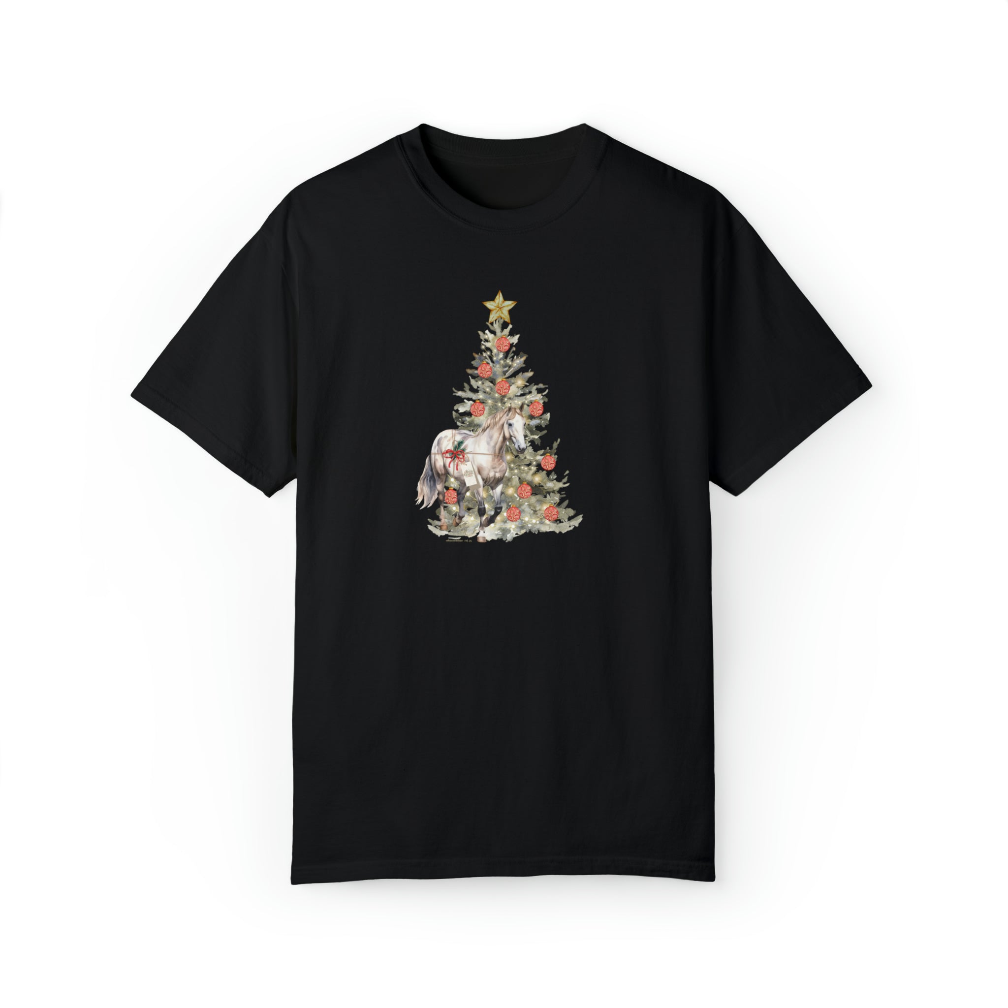 A black T-shirt features a design of a decorated Christmas tree with a golden star on top. A white unicorn is standing partially behind the tree, which is adorned with ornaments, ribbons, and lights. This piece of inspirational wear lets you express yourself during the festive season. Introducing The Gift of A Horse Christmas Garment-Dyed T-shirt by Printify.