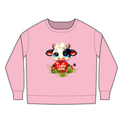 The Printify "I Love Moo" toddler crewneck sweatshirt (sizes 2T-7T) has a cartoon cow with a black eye patch holding a heart that says "I Love Moo," accented by grass and small flowers. Made from a soft cotton-poly blend, it is CPSIA compliant for peace of mind.