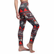 A person is wearing Urban SoulShine & co's Merry Christmas Reindeer Gnome SuperSoft Casual Leggings, crafted in the USA. These festive leggings feature a design reminiscent of an ugly Christmas sweater, with red Christmas trees, snowmen, and snowflakes on a black and red patterned background. The suede-like fabric drapes elegantly as the barefoot individual is shown from the waist down in profile.