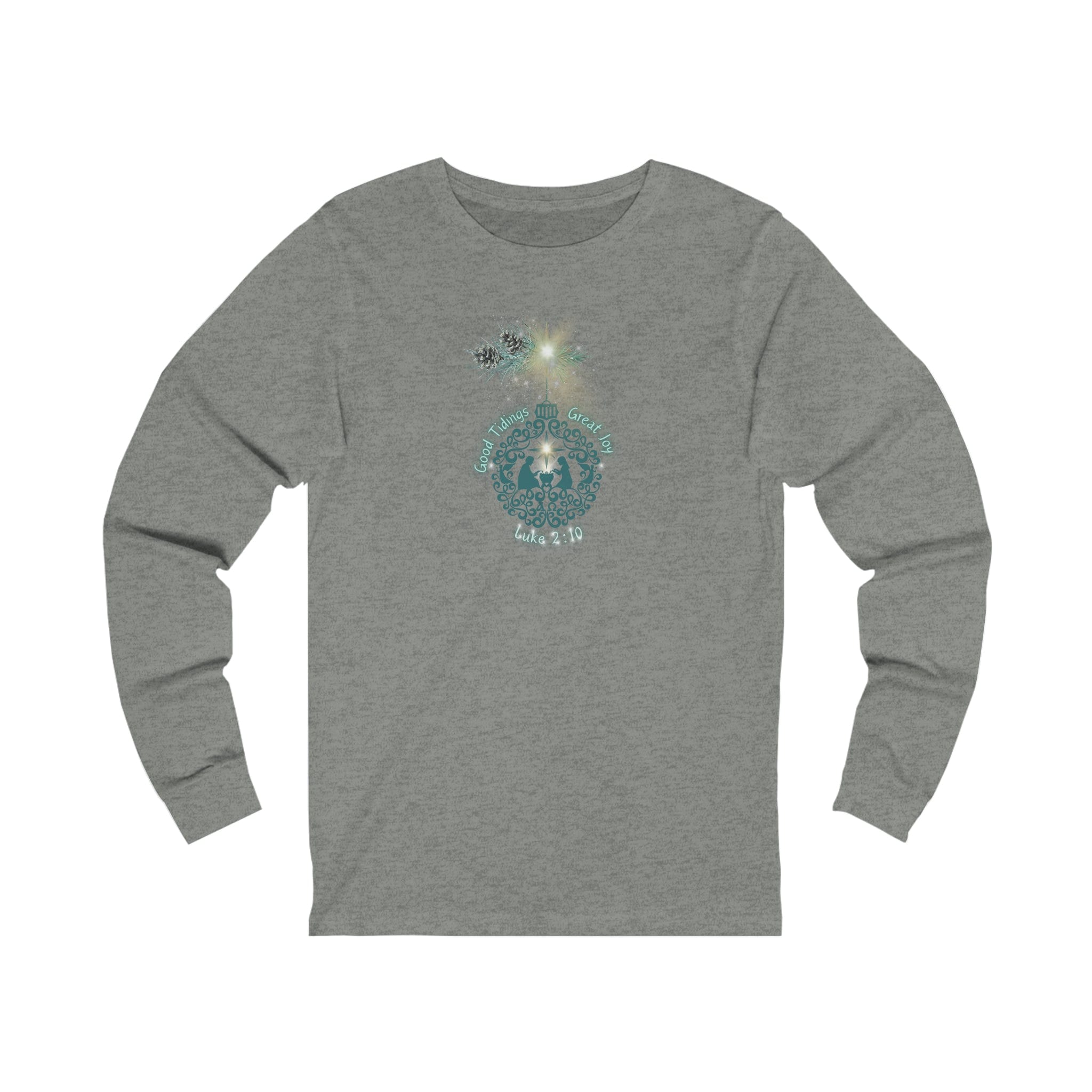 The Good Tidings Great Joy Christmas Wish Glowing Long Sleeve Tee by Urban SoulShine & co features a grayish-green unisex design adorned with a circular floral graphic and subtle text, making it perfect for any season. Its versatile style effortlessly complements a plain white background, making it an excellent choice even for a subtle Christmas ensemble.