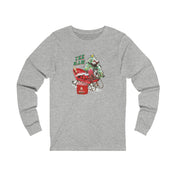 Urban SoulShine & co presents the YEE HAW Santa Is Coming Donkey Claus Long Sleeve Tee (unisex), a gray jersey shirt featuring a cheerful design of a cartoon character riding in a red wagon with a Christmas tree and gifts. Ideal for the holiday season, it adds festive cheer with the phrase "YEE HAW!