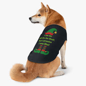 A Shiba Inu dog is dressed in the Urban SoulShine & co "I Ate the Elf On the Shelf Holiday Pet Shirt." This black shirt features a playful design of elf shoes and the humorous phrase, "I ate the Elf on the Shelf, but I promise I was nice!" It's both stylish and machine washable. The dog sits against a plain white background, looking to the side.