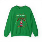 Introducing the Deck The Gnomes Holiday Crewneck Sweatshirt (Unisex) by Urban SoulShine & co. This green polyester cotton blend sweatshirt features a festive design showcasing a gnome in a red and white striped hat, with "Deck the Gnomes" text above, surrounded by red ornaments and colorful lights, all set against a plain white background.