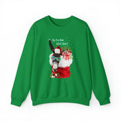 The *Do You Hear What I Hear Donkey Claus Christmas Sweatshirt (Unisex)* by Urban SoulShine & co showcases a vibrant green design featuring a llama adorned with a Santa hat and scarf. The llama sports sunglasses wrapped in string lights while holding a holiday gift, beneath the text "Do You Hear What I Hear?" This unisex sweater provides cozy comfort for all.