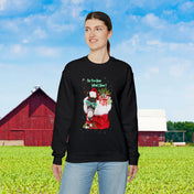 A woman stands in front of a green field and red barn, wearing the Urban SoulShine & co's "Do You Hear What I Hear Donkey Claus Christmas Sweatshirt (Unisex)," which has a festive design featuring a llama in a Santa hat and sunglasses along with the text "Do you hear what I hear?" This heavy blend crewneck sweatshirt perfectly complements the clear blue sky.